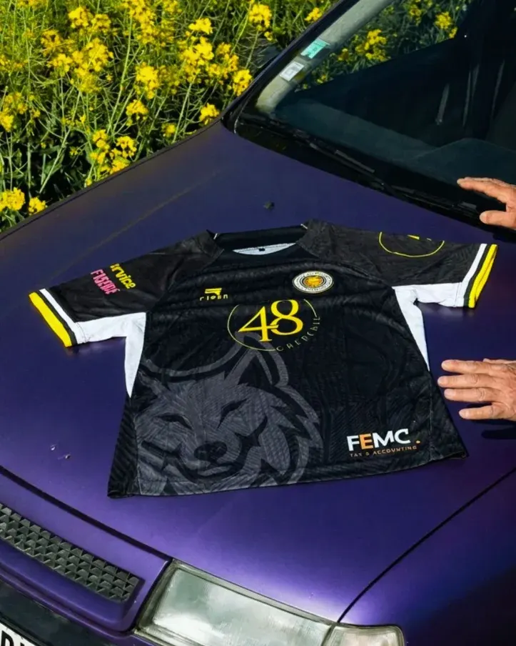 Le maillot domicile de l'Union Molenbeek posé sur le capot d'une voiture, au bord d'un champ